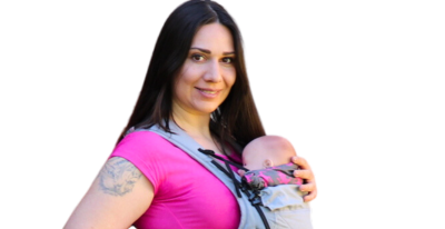 Eine Frau trägt ein Baby in einer Trage.